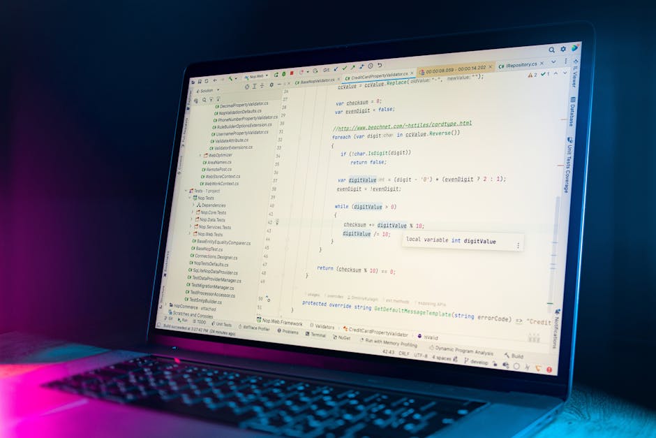 The image shows a close-up of a laptop displaying a code editor with lines of programming code related to website validation and data processing. The screen shows a mixture of text and various coding 